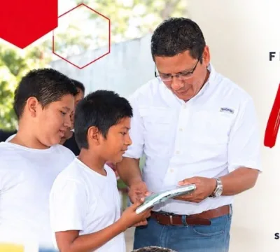 Erick leyendo con estudiantes en una escuela