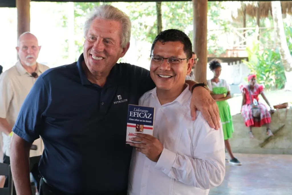 Erick sosteniendo el libro Liderazgo eficaz durante un encuentro de formación