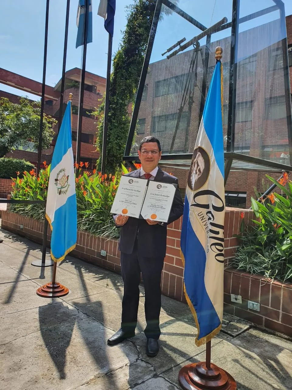 Erick mostrando sus títulos de Maestría en Administración Pública